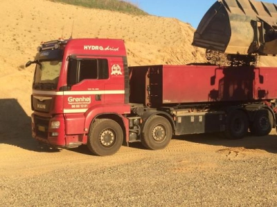 Vi henter dagligt mange læs sand i de lokale grusgrave. Her læsses vi af STOR ged.